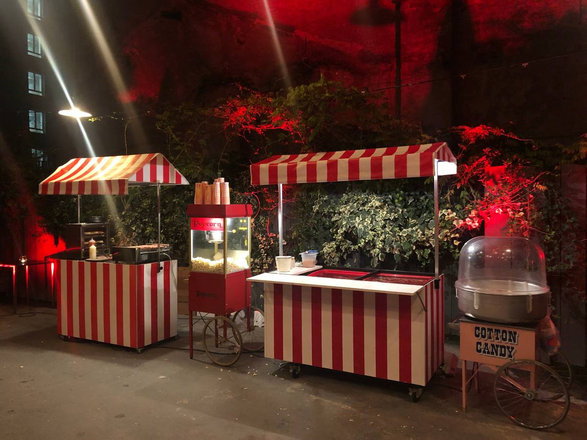 Carretti di hot dog, popcorn e zucchero filato a una festa serale